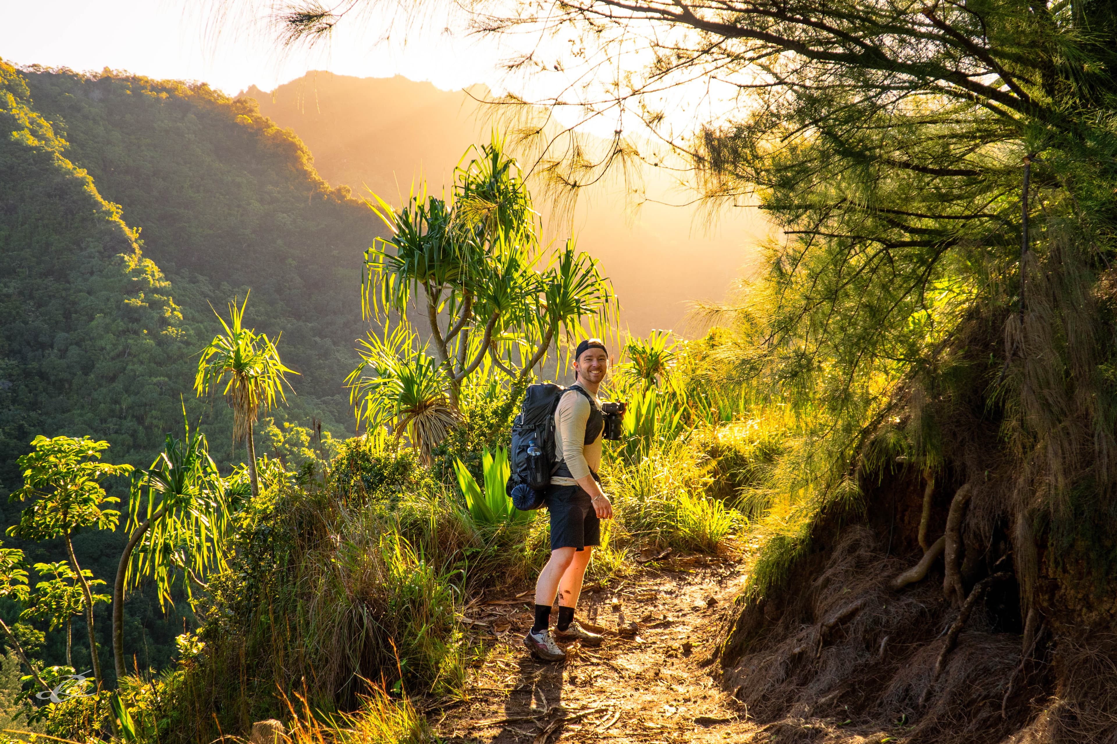Peter backpacking along a trail in Hawaii at golden hour