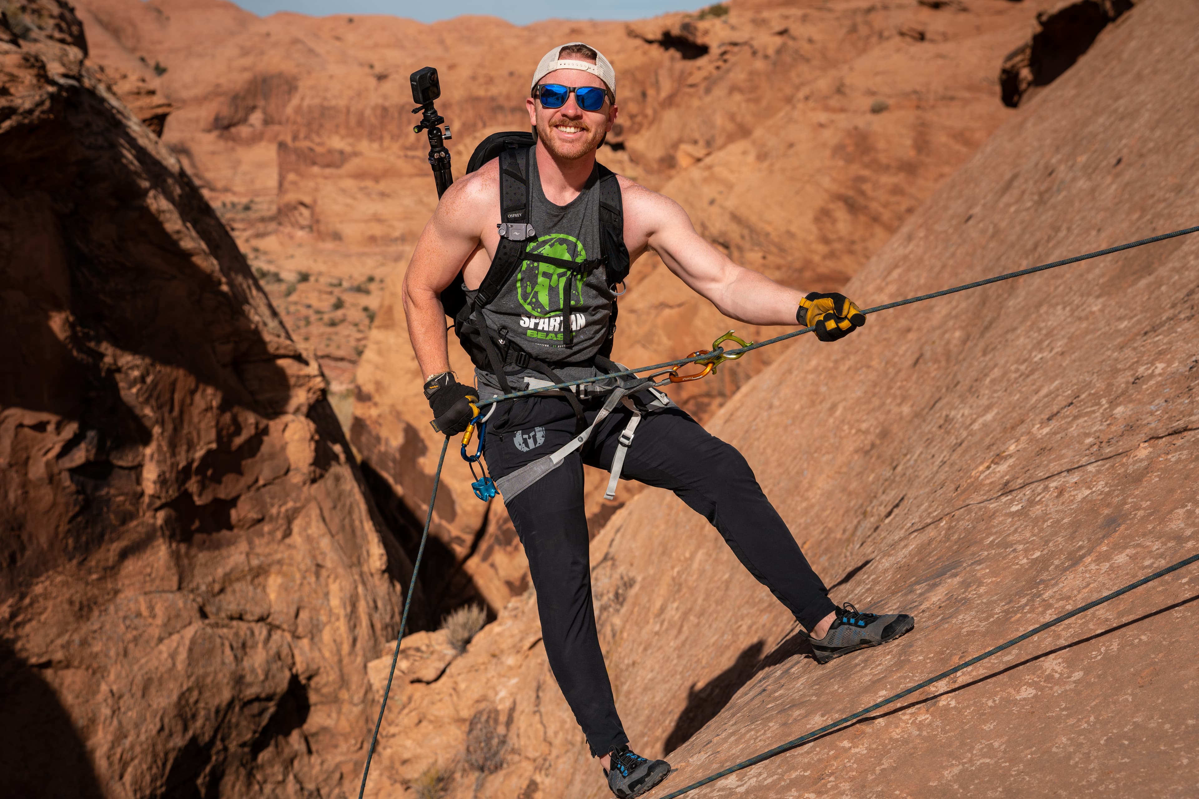 Peter rappelling down red rock cliffs in Moab